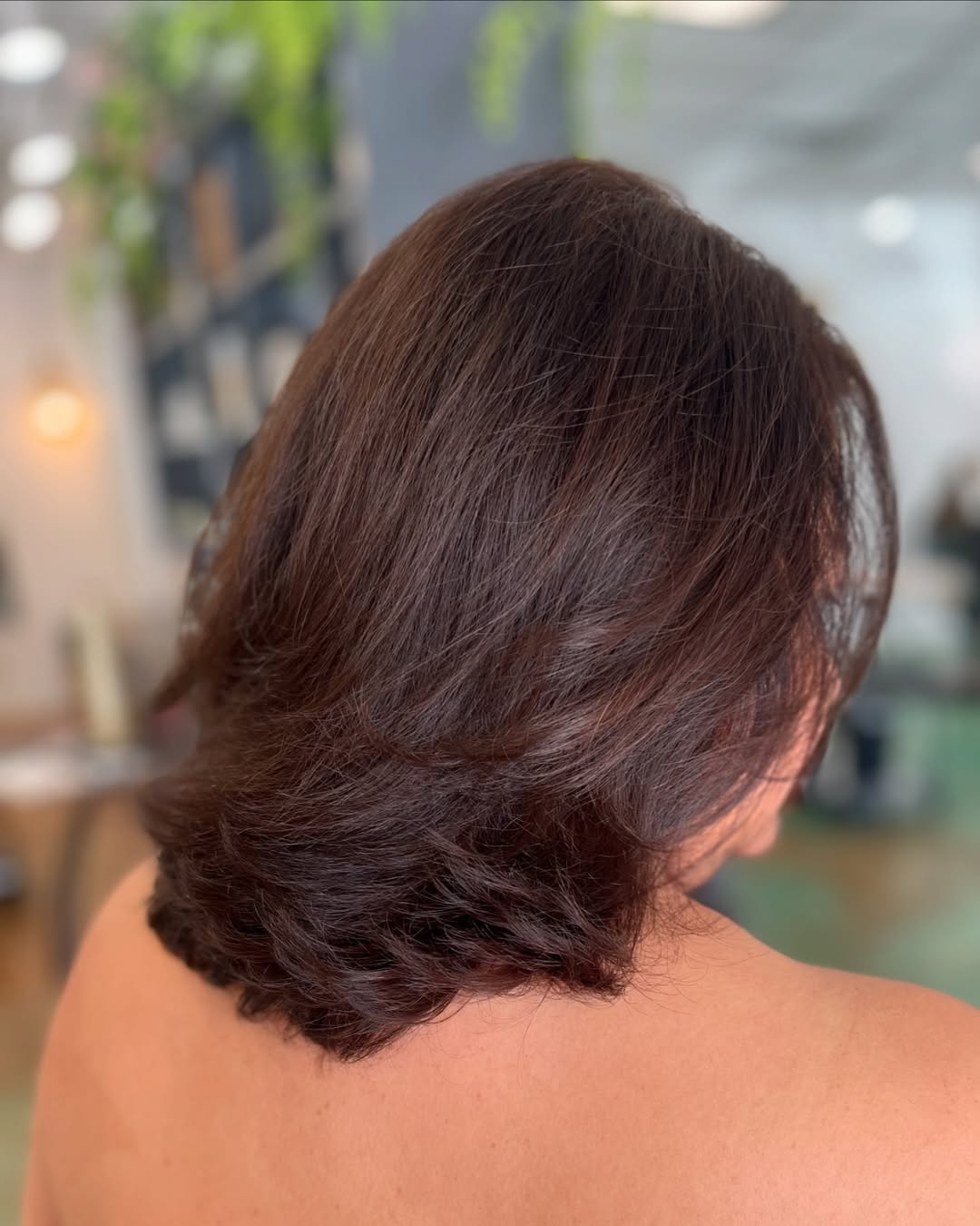 Deep auburn brunette hair color on a voluminous, layered bob haircut, styled by Marie.