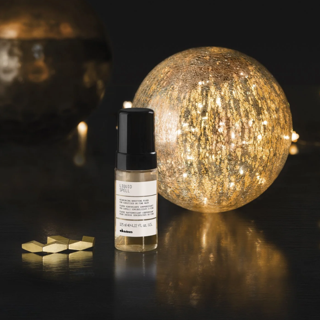 Davines Liquid Spell Reinforcing Bodifying Fluid for sensitized or fine hair, pictured with a glowing decorative sphere and dark background in New Orleans, Louisiana.